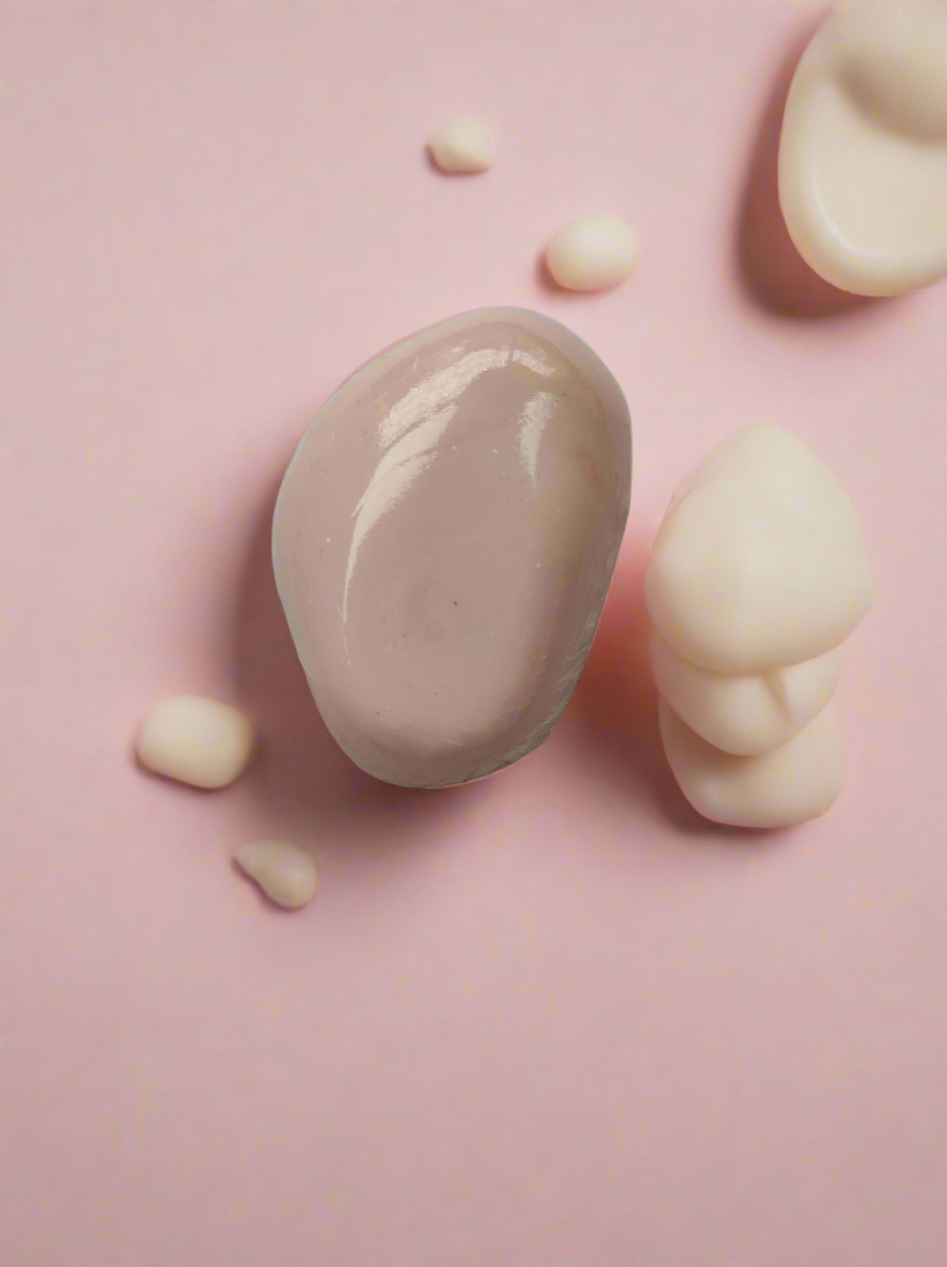 Pink pebble shaped soap bar on grey white backdrop