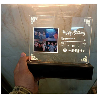 Hand holding Glass like frame with golden LED light and a picture with spotify song link