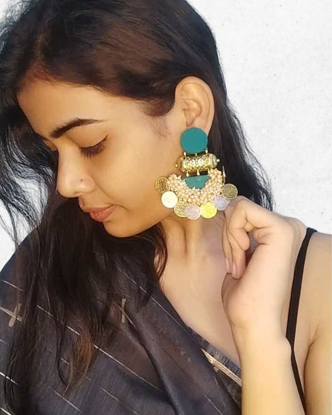 Indian girl with left profile wearing sea green jhumka with silver and golden coins