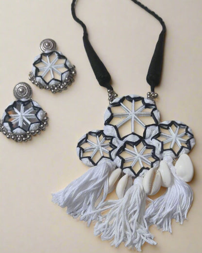 White necklace with mirrors, sea shells and silver charm on white backdrop