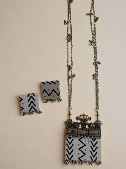 Black and white printed rectangular necklace with matching earrings on white backdrop