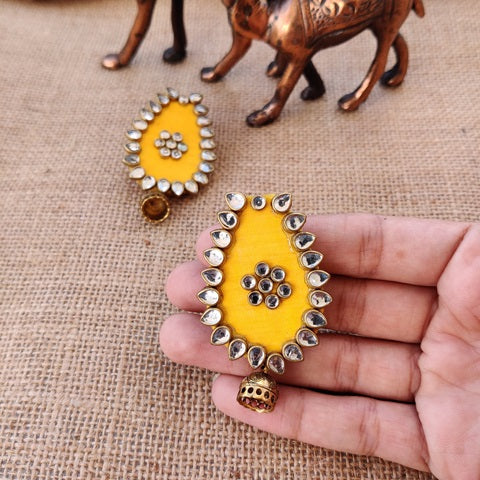 Yellow oval shape earrings with kundan borders and golden mini jhumki at bottom