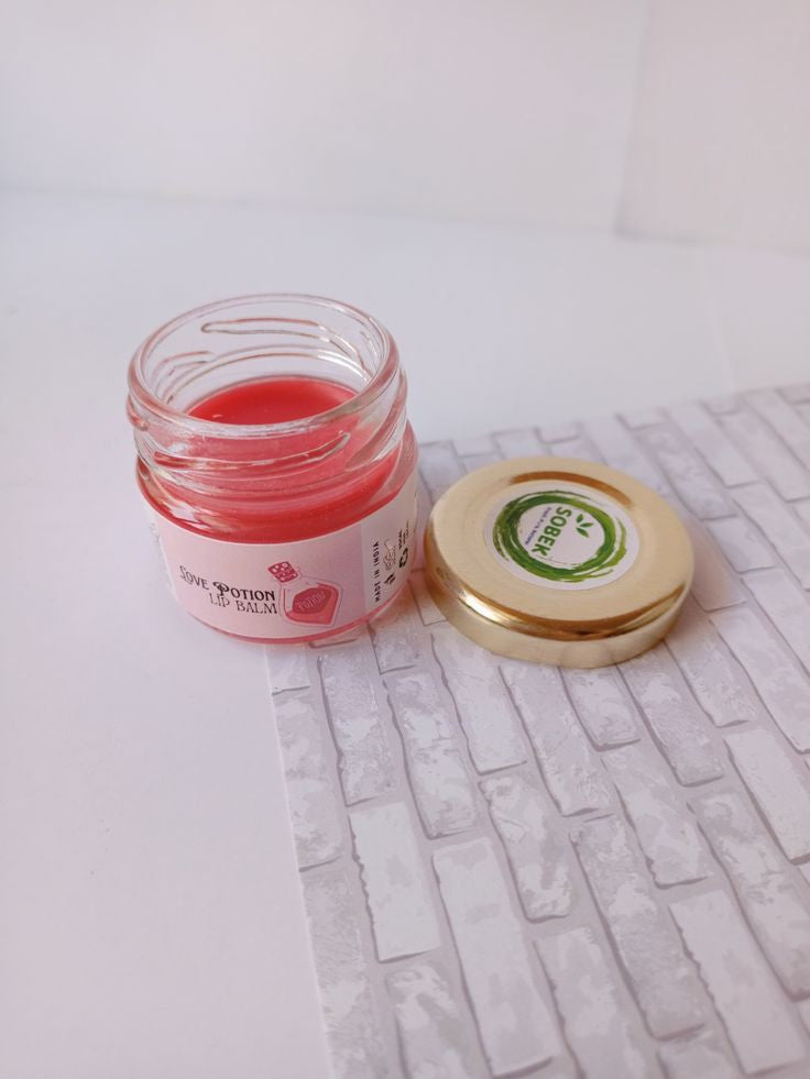 Mini glass jar with sobek red strawberry lip balm on white backdrop