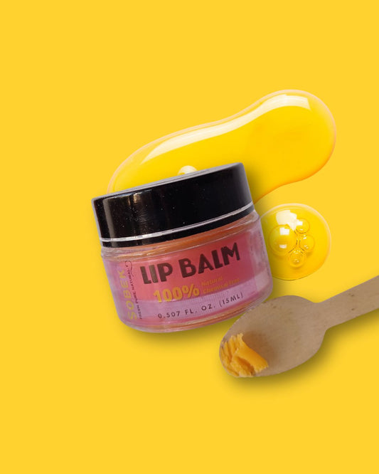 Sobek naturals mango lip balm on yellow backdrop with tiny spoon with lip balm on it