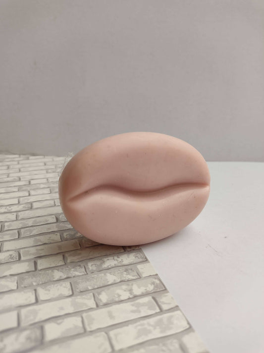 pink coffee bean shaped soap bar on white grey backdrop