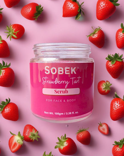 Strawberry face and body scrub in pink glass jar with strawberries around it