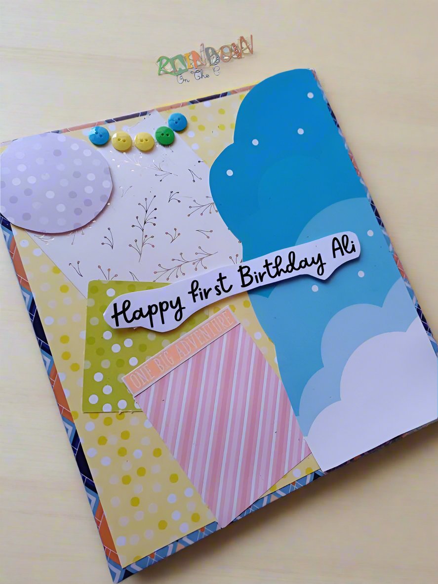 Baby birthday scrapbook in pastels on white backdrop