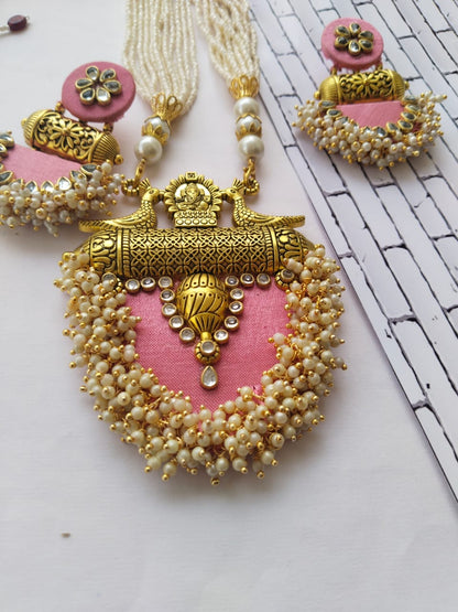 Baby pink necklace with golden charm, beads and kundan with matching earrings on white backdrop