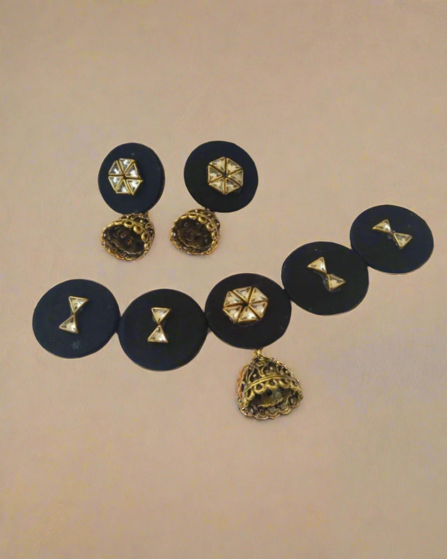 Black round choker necklace with kundan details and matching earrings on white backdrop
