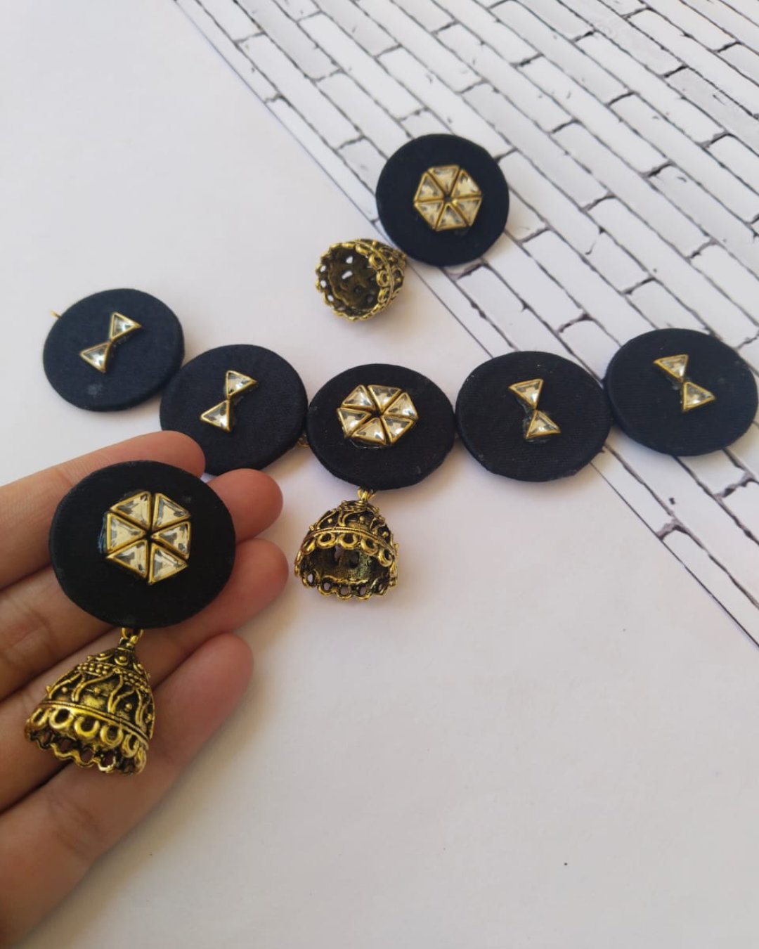 Black round choker necklace with kundan details and matching earrings on white backdrop