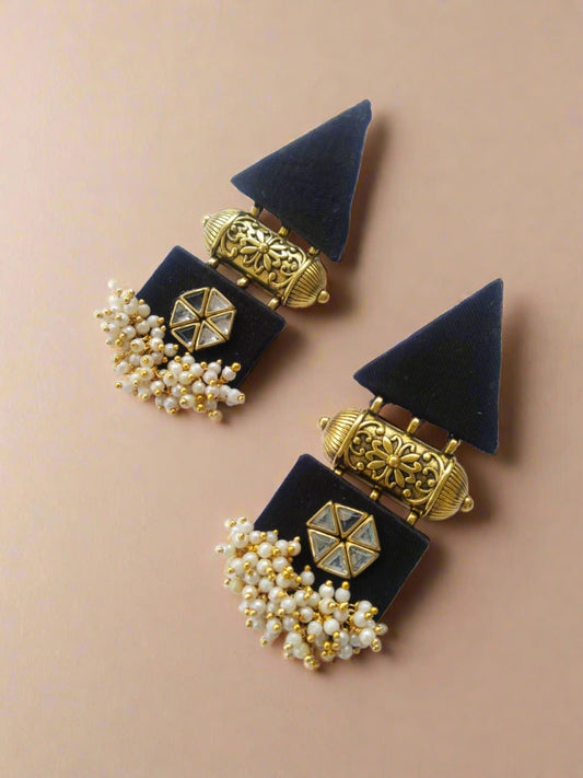 Black and golden triangular shaped traditional earrings with golden tabiz charm on white backdrop