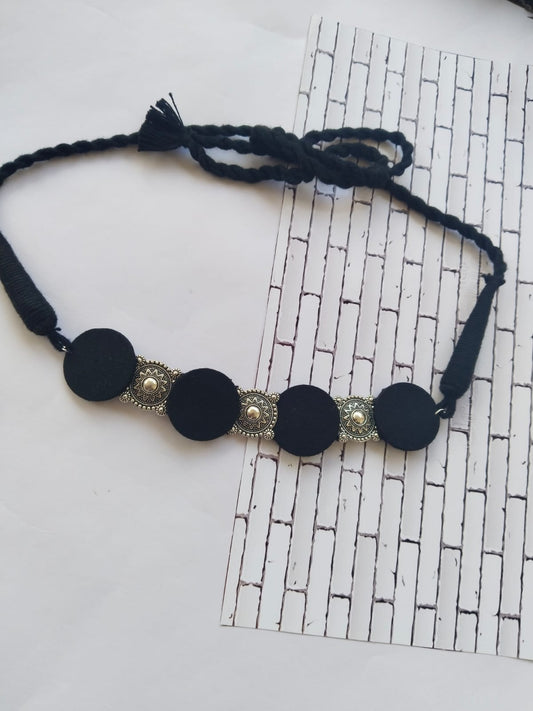 Black choker necklace with round charms in silver and black on white backdrop