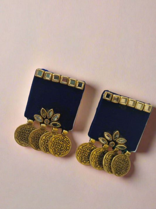 Black square studs earrings with golden coins and kundan on white grey backdrop