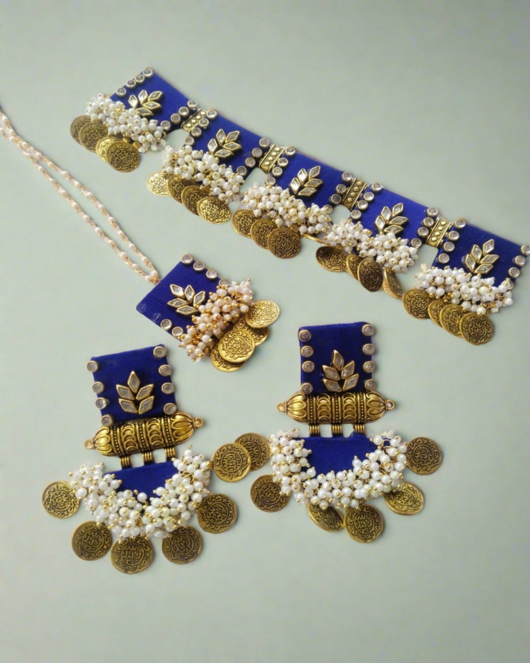 Blue and golden square choker necklace with matching earrings on white backdrop