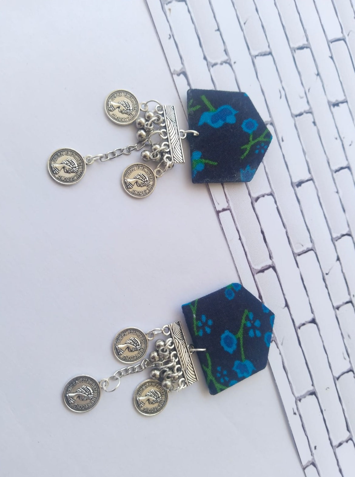 Blue floral print earrings with silver chain and coins latkan on white grey backdrop