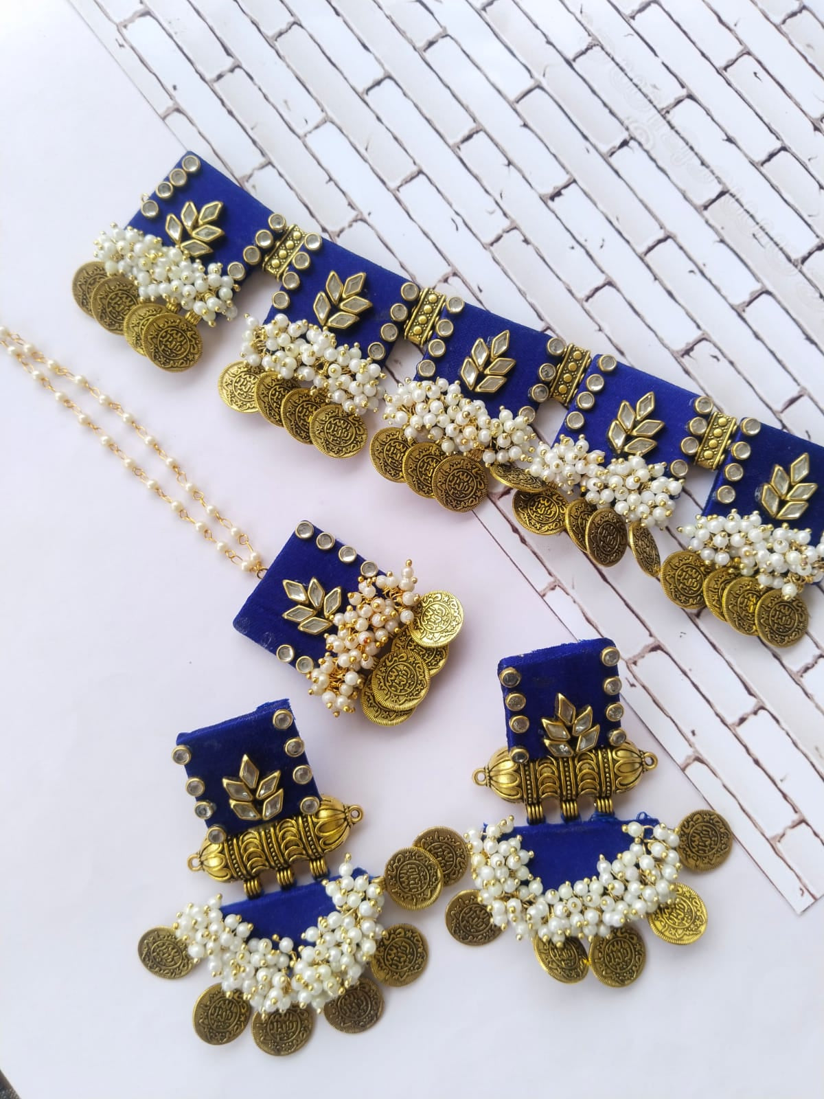Blue and golden square choker necklace with matching earrings on white backdrop