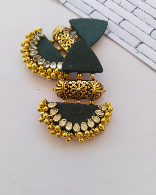 Bottle green earrings with golden tabiz, golden beads and kundan on white grey backdrop
