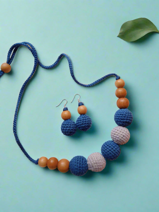 Dark blue and grey crochet round beaded choker necklace and earrings on white backdrop