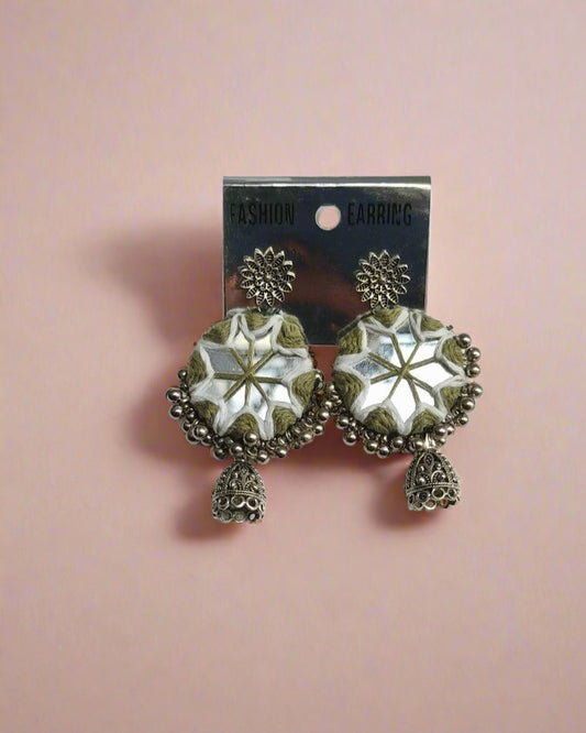 Green white round earrings with silver beads, mirror and charm on white grey backdrop