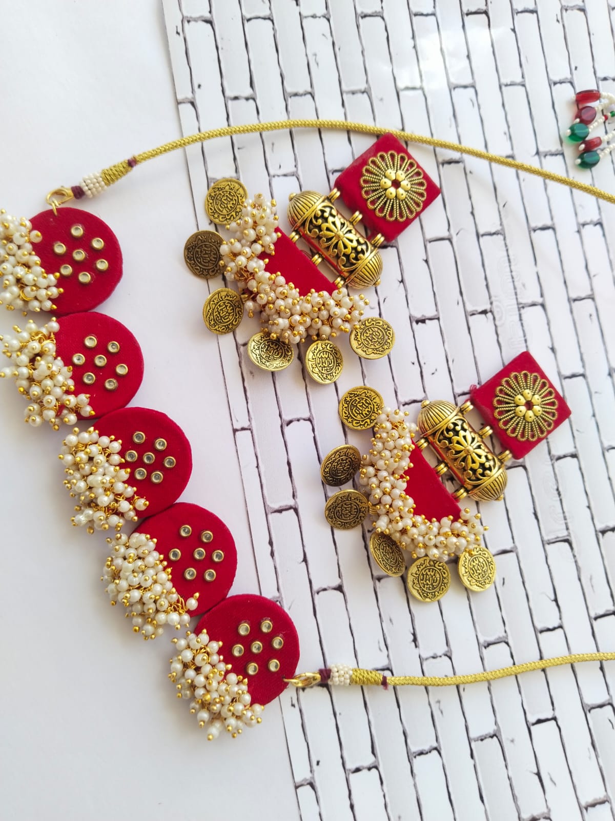 Hot red choker necklace with golden beads and coins with matching earrings on white backdrop