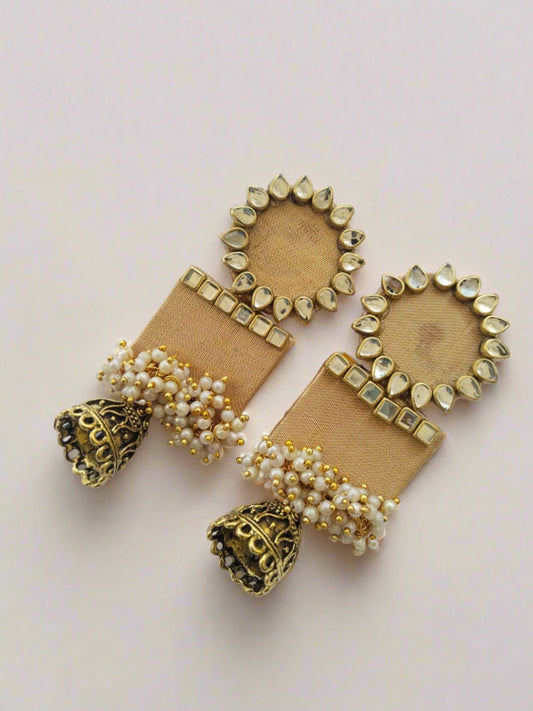 Ivory brown rectangular jhumka with white and golden beads on white grey backdrop