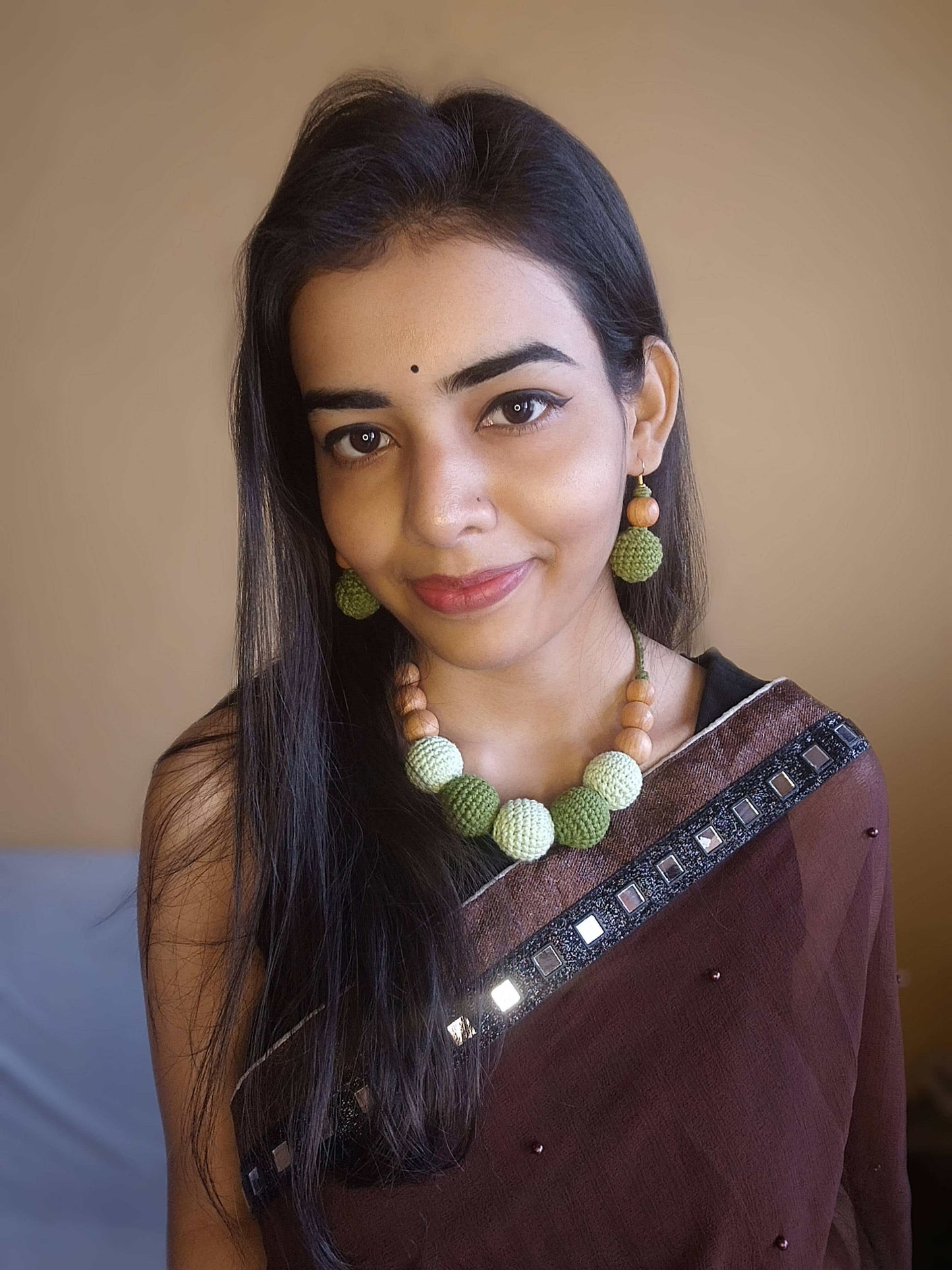 Indian woman in brown saree wearing Dark and light green crochet round beads choker necklace and earrings