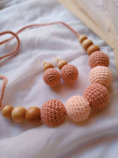Pastel peach and light pink crochet round beaded choker necklace and earrings on white backdrop