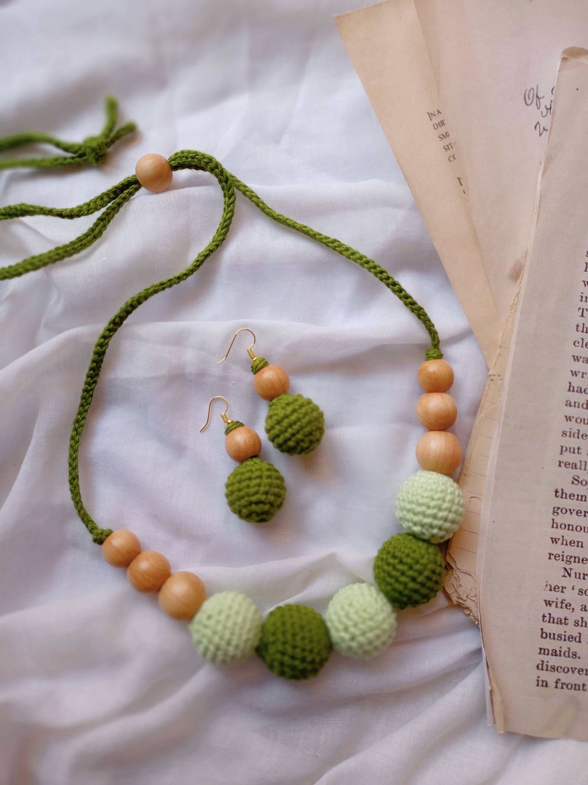 Dark and light green crochet round beads choker necklace on white backdrop