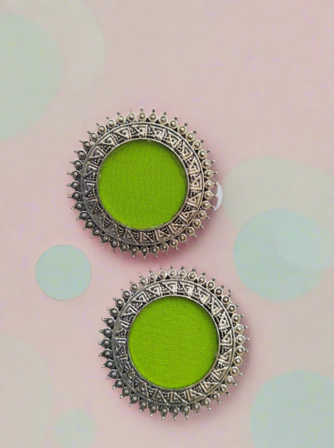 Lime green round studs earrings with silver chain border on white backdrop