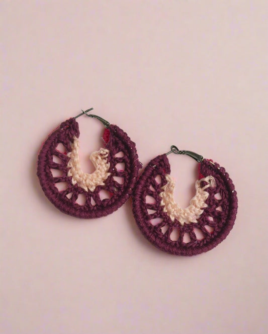 Maroon and pink crochet hoops earrings on white grey backdrop