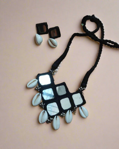 Black and white mirror necklace with sea shells on brown backdrop