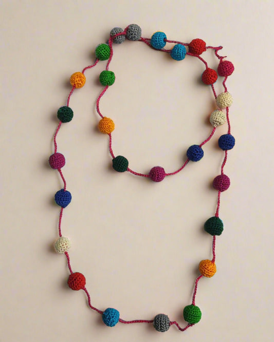 Pom pom multicolor adjustable necklace on white backdrop