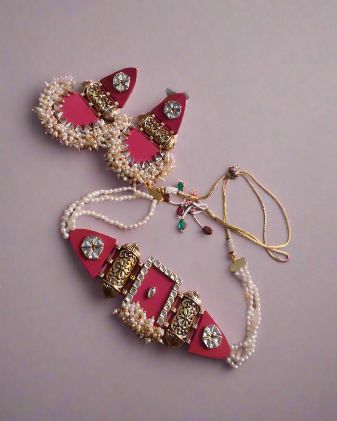 Pink and golden choker necklace and earrings with white beads on brown backdrop