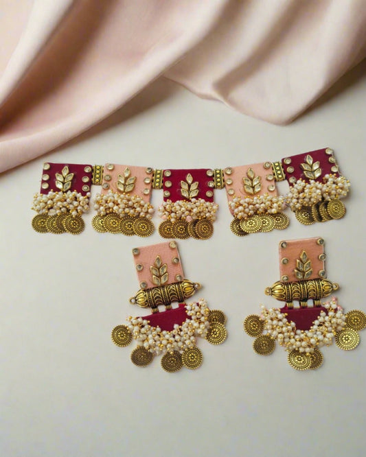 Red and pink and golden square shaped choker necklace with matching heavy earrings on white backdrop