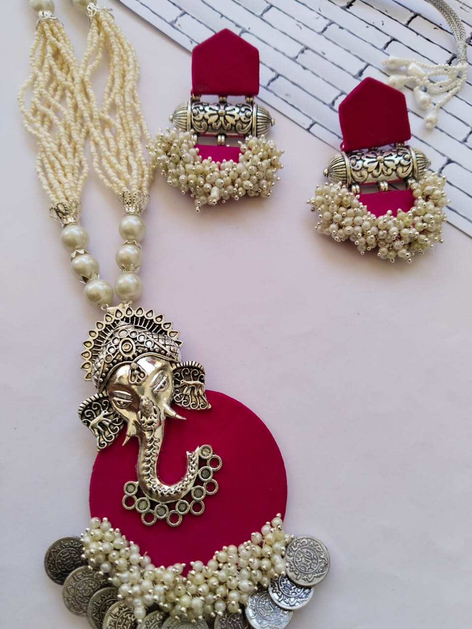 Dark pink necklace pendant with ganpati charm, white beads and silver coins and matching earrings