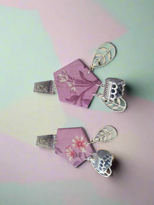 Pink floral printed earrings with silver charms at bottom on white backdrop