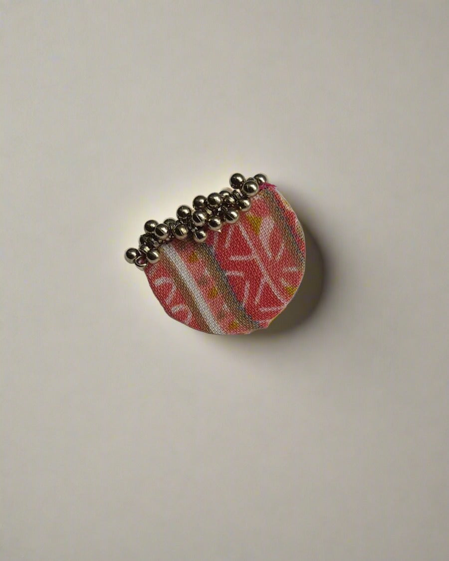 Pink printed semi round finger ring with silver beads on white backdrop