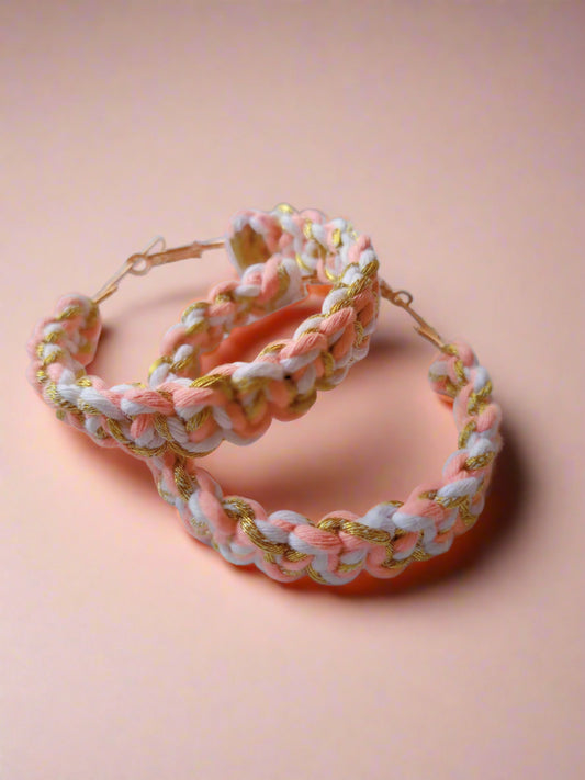 Pink white and golden crochet knitted hoops earrings on white backdrop