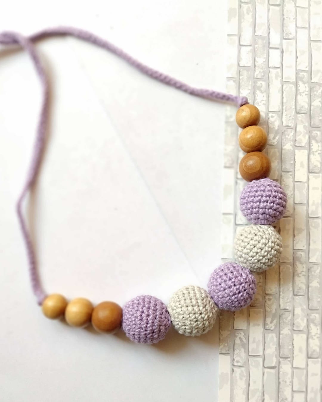 Purple and white crochet beaded necklace with grey and white backdrop