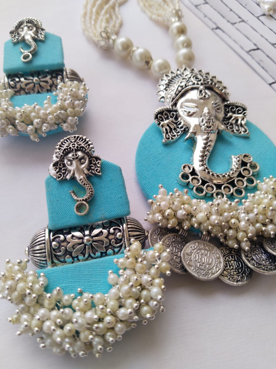 Light blue necklace with ganpati charm and silver beads with matching earrings