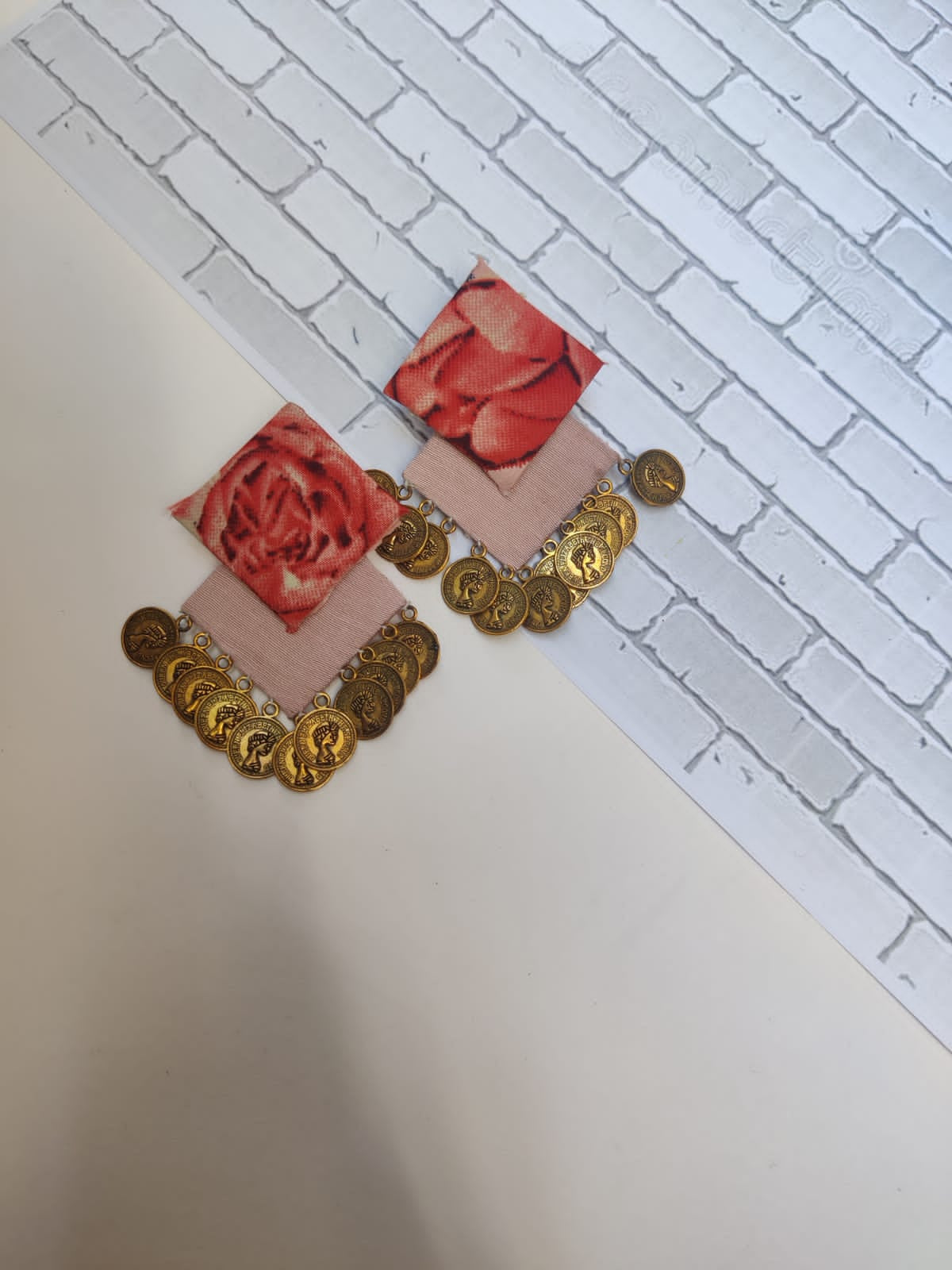 Pink rose printed earrings with golden coins on white grey backdrop