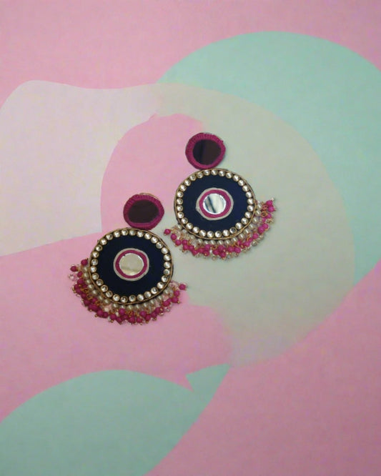 Dark pink and black mirror round earrings with beads and kundan on border on a white backdrop