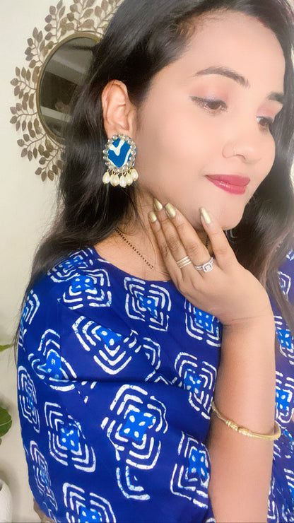Indian woman smiling wearing blue outfit highlighting her blue printed round studs earrings with kundan border and white pearls