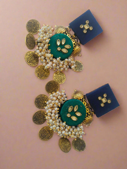 Blue and dark green earrings with golden tabiz, coins and white beads on white backdrop