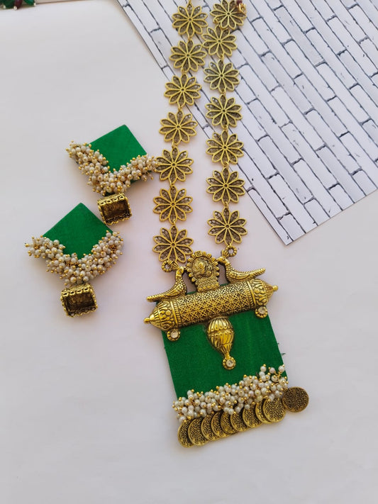 Dark green necklace and earrings with golden charm,beads and golden coins on white backdrop