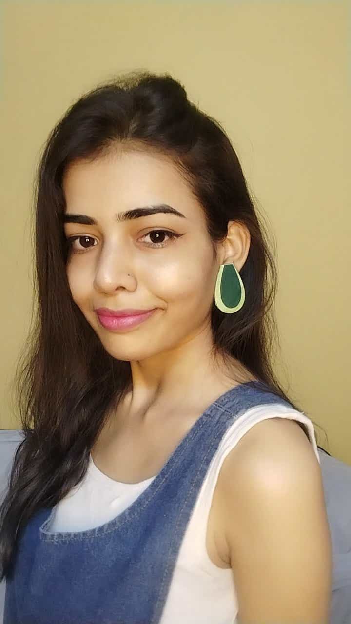 Indian girl wearing blue white outfit with green oval avocado shape studs earrings