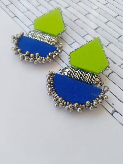 Light green and dark blue earrings with silver tabiz and beads on white backdrop