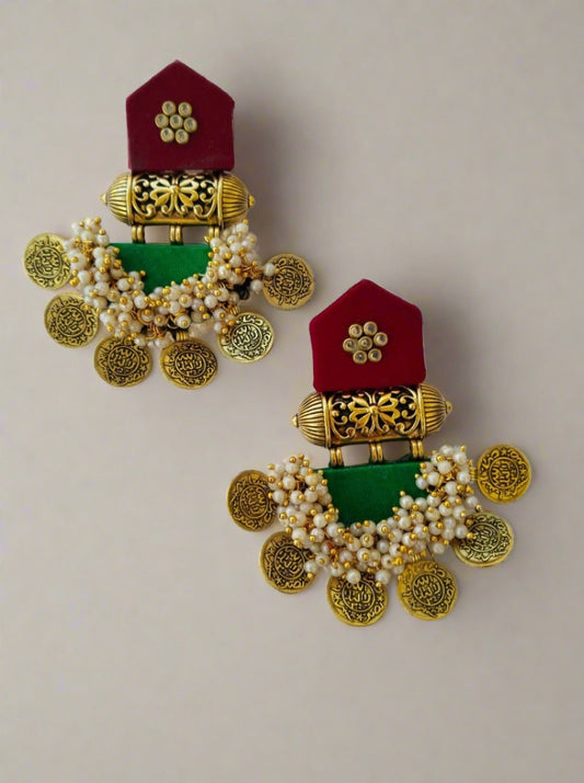 Maroon and dark green jhumka earrings with golden tabiz, white beads and coins on white backdrop