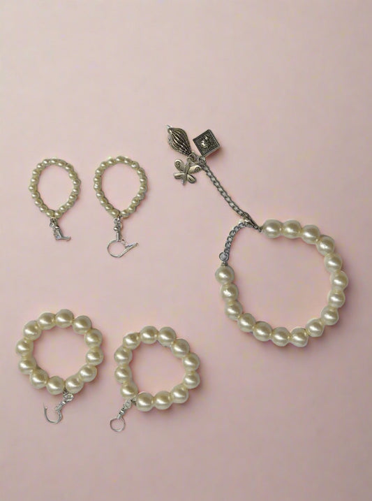 White pearls only set of bracelet and earrings on white grey backdrop