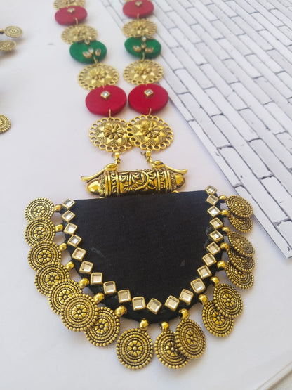 Green black and red necklace with golden coins and kundan on white backdrop